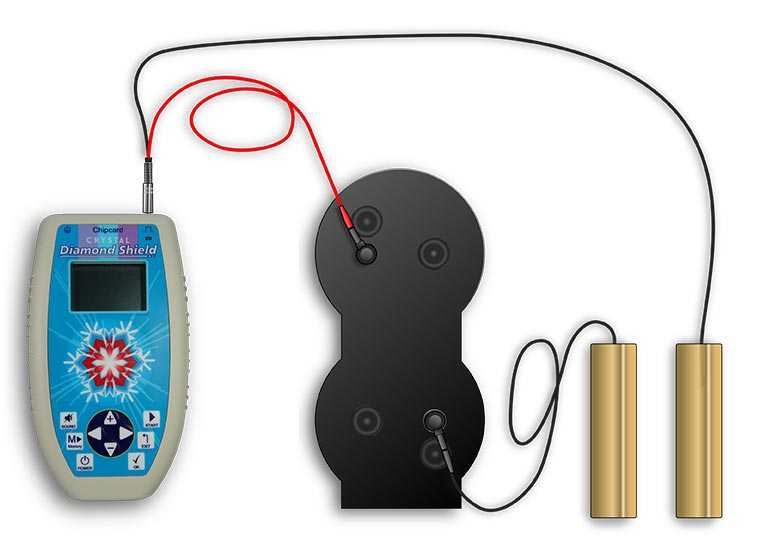 Next to the blue zapper device lies the black fractal amplifier and is connected by cable with golden hand electrodes